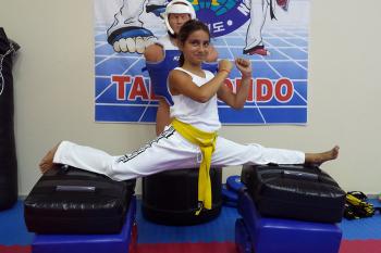 Αθλήτρια κατά τη διάρκεια προπόνησης πάνω στο στη βελτίωση τεχνικών του Taekwondo